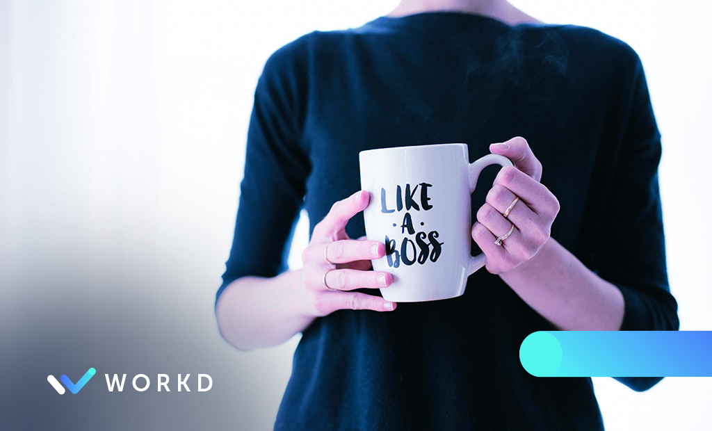 Woman holding a like a boss mug.